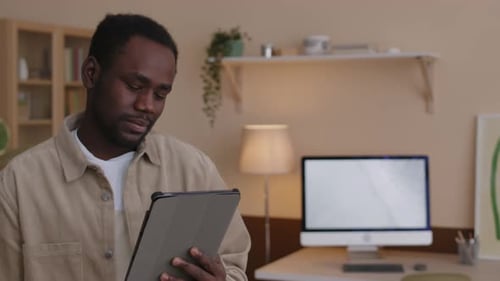 Black Man on Video Call via Digital Tablet at Home