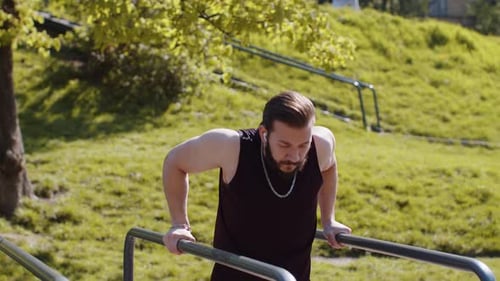 Athletic Lebanese Man in Sportswear Practicing Dips on Parallel Bars Training Triceps on Playground