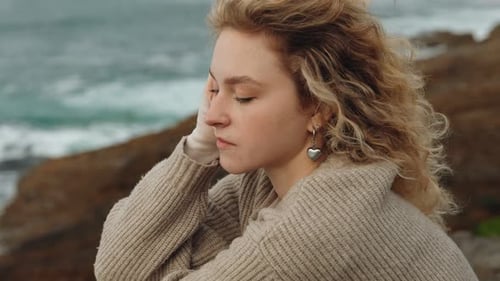 Solitude By the Sea Contemplative Young Woman on Rocky Ocean Cliff
