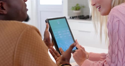 Couple Controlling Smart Home With Tablet Technology