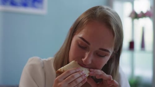 Woman Eating a Sandwich Close Up Indoors
