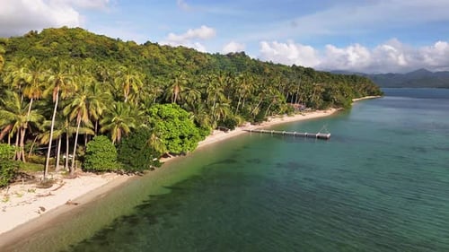 Tropical shoreline of Las Cabañas Beach with calm waters and palm-fringed sand Palawan Philippines