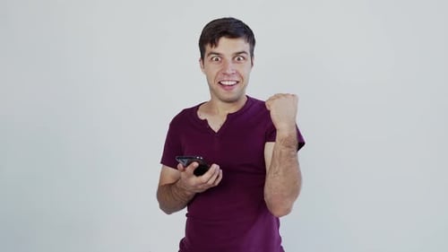 Man Reacts with Excitement to Smartphone News
