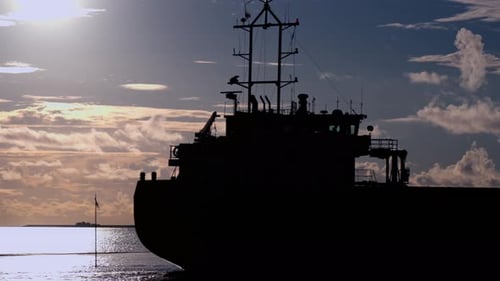 Cargo Ship Silhouette on the Ocean at Sunrise