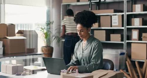 Woman Works on Laptop in Office Supply Room