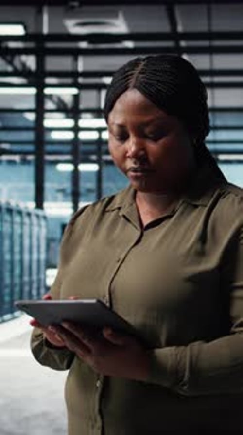 Softwareentwickler für vertikale Videorechenzentren überwacht Rechenzentrumsmetriken auf dem Tablet