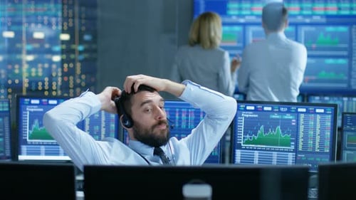 Der Börsenhändler schließt über das Headset einen Deal mit einem Großkunden ab. Er arbeitet mit anderen Brokern zusammen