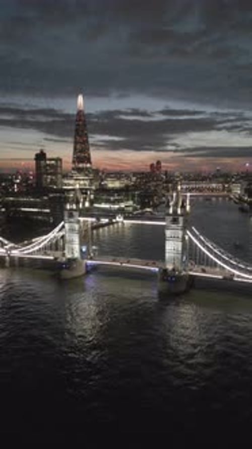 Aerial video of the city of London and the lighthouse bridge in London at night