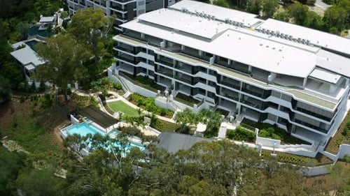 Aerial 4K Drone Flyover Apartment Complex Rooftop With Blue Tropical Pool Area Like A Luxury Resort