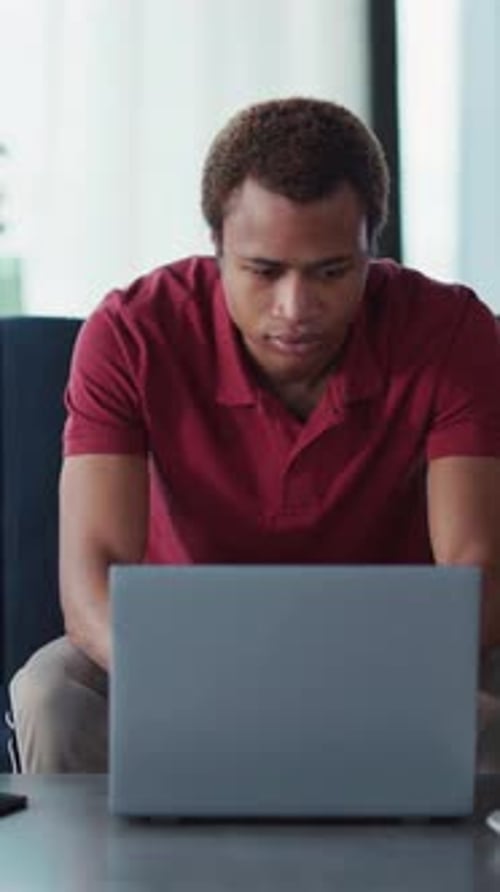 Young Adult Working on Laptop in Living Room