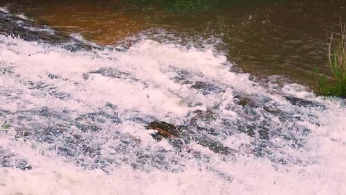 Crystal clear water waterfall going down the mountain in slow motion