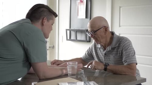 Senior Man Taking Pills with Woman Present