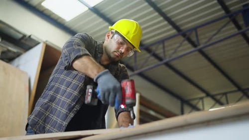 Close up and lower view carpenter or woodworker or charpentier man use drill to work with wood