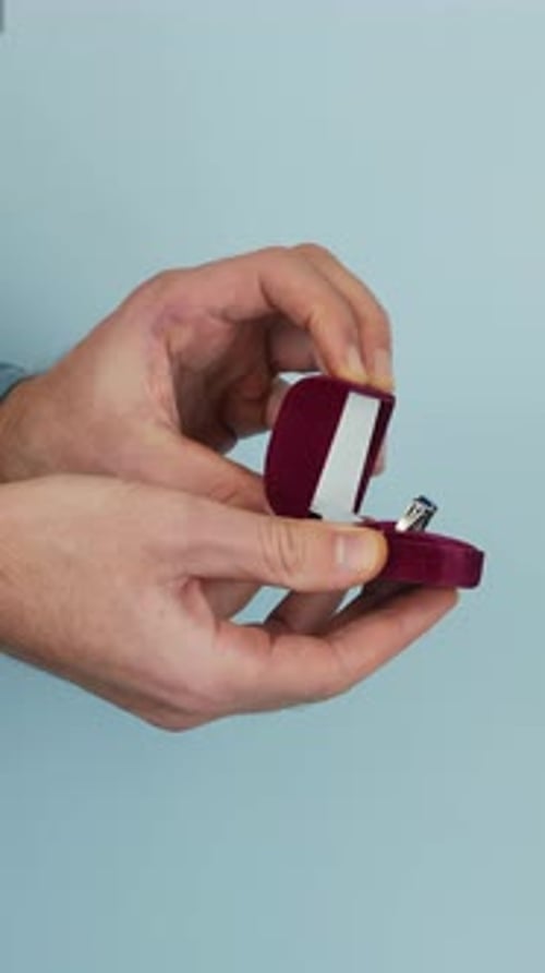 Hands Opening a Velvet Ring Box Revealing Diamond