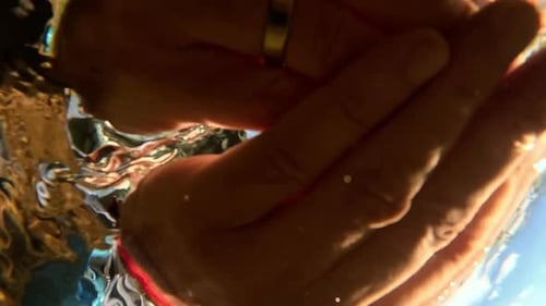 Man Taking Clear Drinking Water From a Stream in Forest