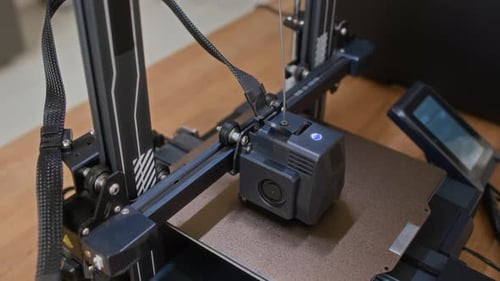 Gros plan de l'extrudeuse d'imprimante 3D appliquant des couches de plastique sur la plate-forme
