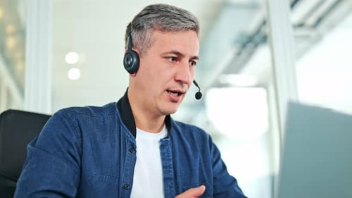 Focused Businessman With Headset Working Remotely From Modern Office