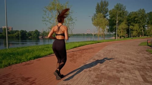 Woman Jogging in an Urban Park on Sunny Day