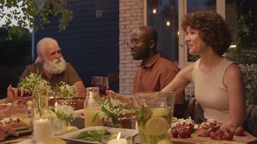 Friends Gather for Dinner at Night Outside