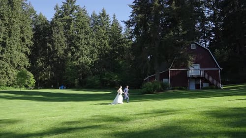 Groom and bride running in a farm on their wedding day. Sloe motion.