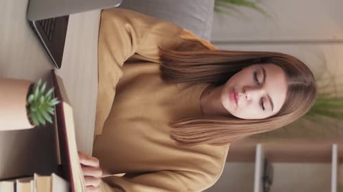 Young Woman Studying at Desk is Tired