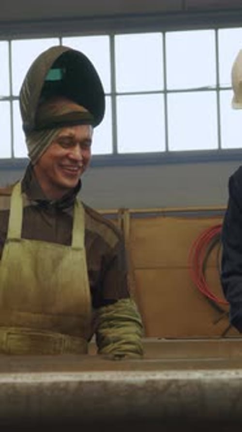 Welding Professionals Engaged in Collaborative Efforts Within an Industrial Workshop Setting Media