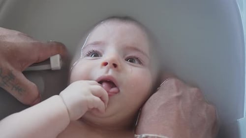 Happy Baby Relaxing in Tub Being Watched By Parents