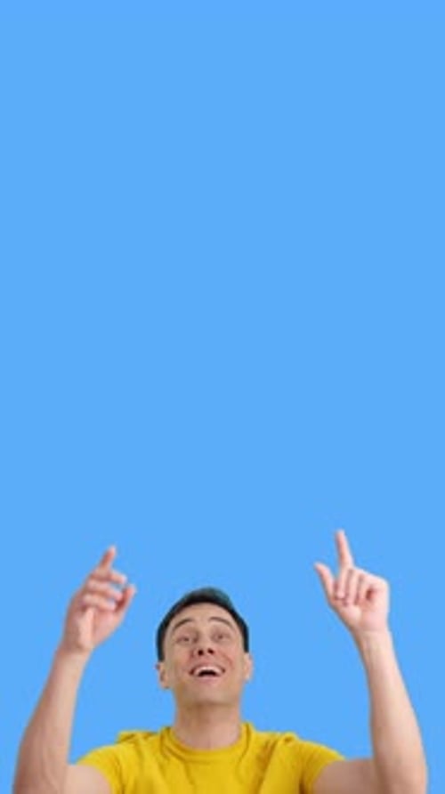 Man Pointing Upward Against Blue Chroma Key Background