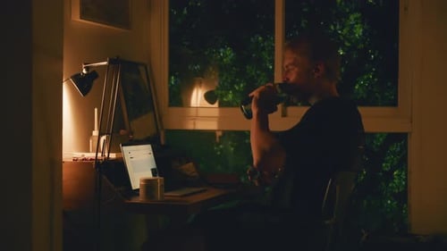 Young Man Works Remotely on a Laptop Computer at His Home Office Desk Concentrated Student Studying