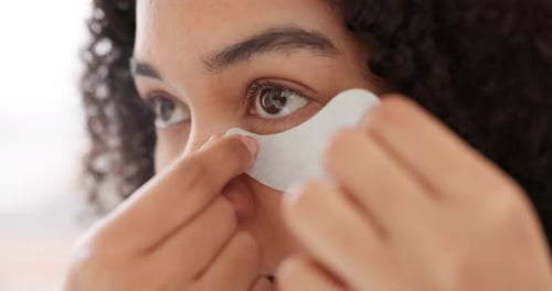 Woman Applies Eye Mask for Beauty Treatment