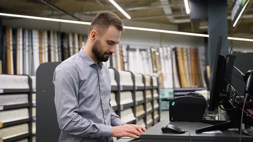 Salesman in a Wall Covering Store Checking Wallpaper on Computer