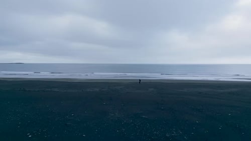 Isolated View Of A Man At Stokksnes Seacoast In Stokksnesvegur, Southeastern Iceland. Aerial Drone
