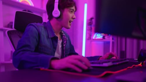 Excited Young Adult Gaming Online at Home