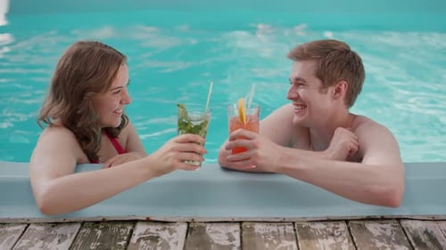 Couple Enjoying Drinks By the Pool on a Sunny Day Perfect for Relaxation and Fun