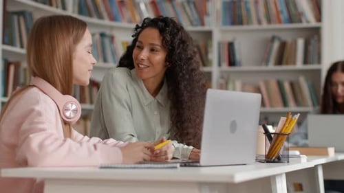 Students Studying Together In Library With Laptop