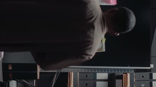 Man Investigating With Papers at Detective Board