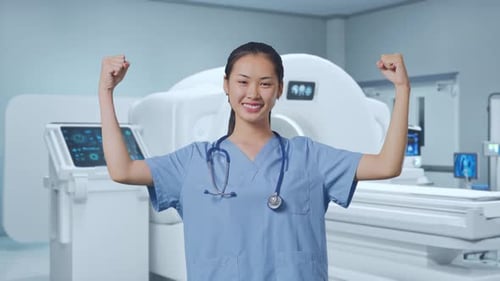 Smiling Medical Professional Flexes Arms in Hospital