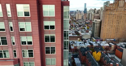 Aerial truck shot. Highrise apartment building in urban American city in USA. Red exterior of skyscr