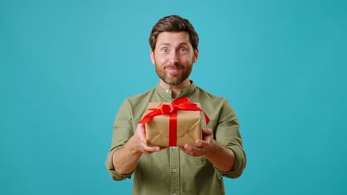 Cheerful Man Holding Out Gift Box