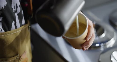 Barista Pouring Fresh Brewed Coffee And Milk Foam In Cappuccino Or Latte In Cafe For Take Away