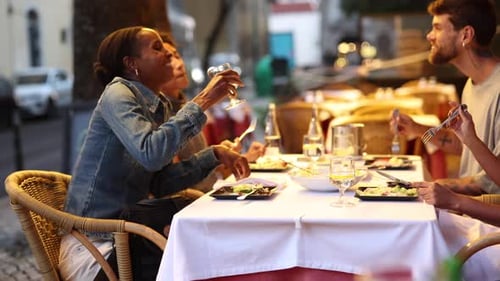 Friends enjoying dinner and drinks at outdoor restaurant