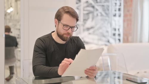 Man Reviewing Documents and Celebrating Success