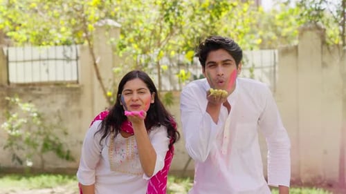 Indian Couple Blowing Holi Colors in Camera