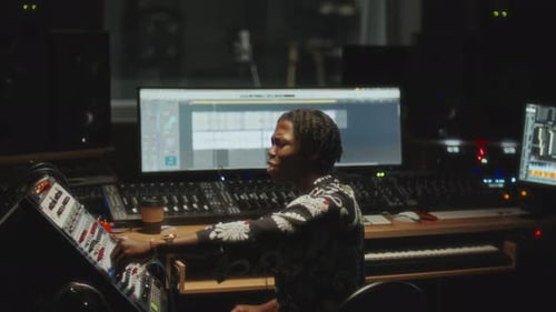 Black Music Producer Working on Audio Mix in Recording Studio