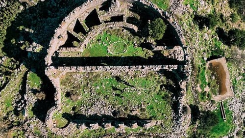 Aerial view of ancient ruins amidst greenery, Greece.