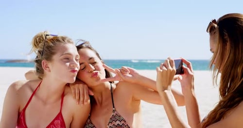 4k video footage of friends taking photos on the beach