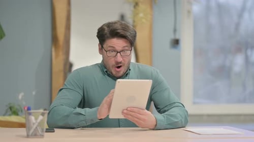 Man Using Tablet is Surprised and Celebrates
