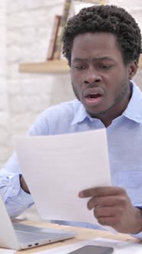 Young Man Reads Paper and Reacts Positively