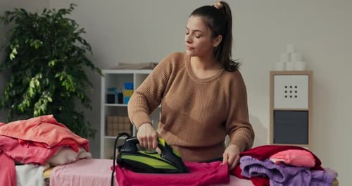 Woman Contentedly Ironing Laundry at Home