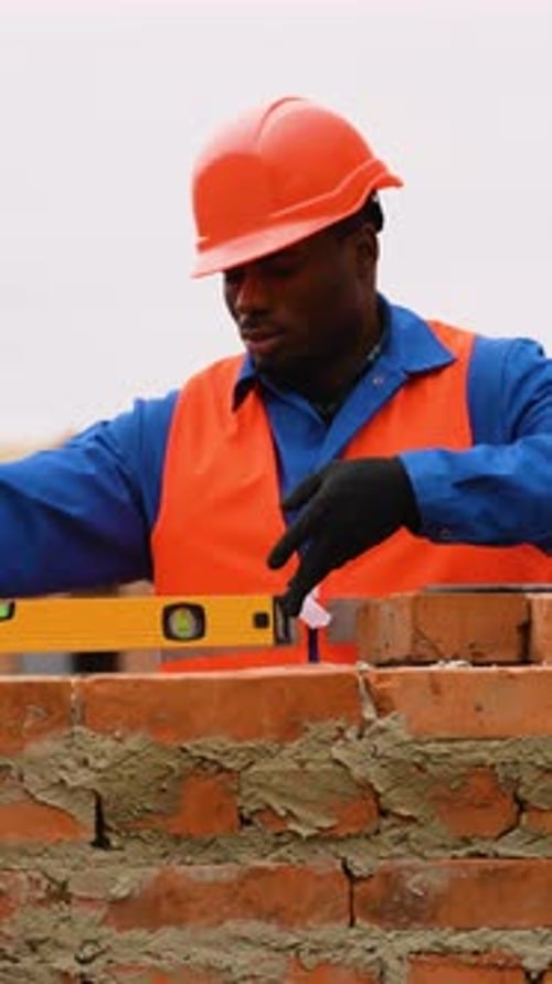 Bricklayer Using Level Tool at Construction Site
